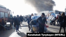 Торговцы уносят свой товар с сгорящего рынка. Алматы, 17 ноября 2013 года.