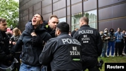 Polițiștii germani rețin un participant la protestul de la Freie Universitat (FU), Universitatea Liberă din Berlin.