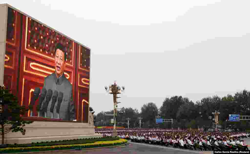Președintele chinez Xi Jinping este văzut pe un ecran gigant în timp ce ține un discurs în Piața Tiananmen la 1 iulie. Liderul autoritar a salutat cursul „ireversibil” al Chinei către statutul de mare putere și a avertizat alte țări să nu amenințe cea mai populată țară din lume. 