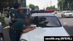 Узбекские милиционеры проверяют автомобиль на одной из центральных улиц Ташкента.