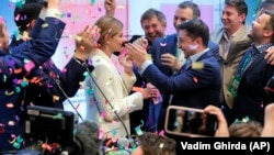Ukraine's president-elect Volodymyr Zelenskiy and his wife, Olena Zelenska, greet their supporters at his headquarters after his election victory on April 21. 