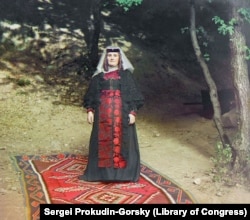 O femeie georgiană pozează cu hainele ei cele mai bune.