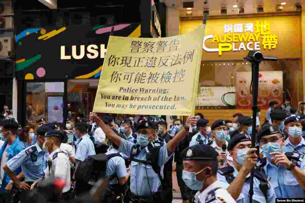 Poliția instalează un banner de avertizare în centrul orașului Hong Kong după ce autoritățile au refuzat permisiunea de a desfășura un protest în timpul celei de-a 100-a aniversări a fondării Partidului Comunist.