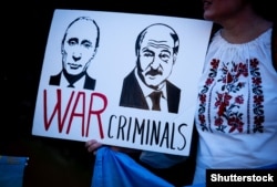 Imagine de la un protest din Londra, martie 2022, în care președinții Putin și Lukașenko sunt caracterizați drept criminali de război.