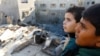 Palestinska djeca gledaju na štetu na mjestu izraelskih udara na kuće, usred tekućeg sukoba između Izraela i Hamasa, u Khan Younisu u južnom pojasu Gaze, 10. decembra 2023.