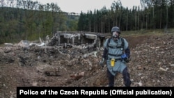 Un pirotehnist inspectează locul după explozia de la un depozit de muniție de lângă Vrbetice, Republica Cehă, ce a avut loc pe 20 octombrie 2014.