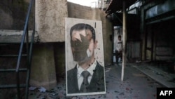 Un portret distrus al președintelui sirian destituit Bashar al-Assad se află într-o clădire guvernamentală devastată din Damasc, pe 8 decembrie 2024.