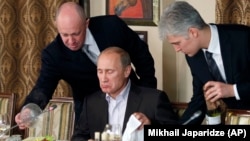Prigojin (stânga) servindu-i cina premierului rus Vladimir Putin la restaurantul lui Prigojin de lângă Moscova, în 2011.