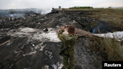 Ресейшіл қарулы сепаратист Украинада құлаған Boeing 777 ұшағының қалдығын суретке түсіріп жүр. Донецк, 17 шілде 2014 жыл.