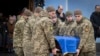 Soldații poartă un sicriu al soldatului ucrainean Andriy Kuzmenko, care a fost ucis în războiul Rusia-Ucraina, în timpul unei ceremonii de rămas bun la Mănăstirea Sf. Mihail din Kiev, pe 10 ianuarie.