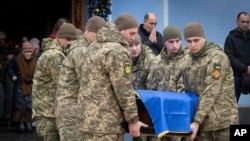 Soldații poartă un sicriu al soldatului ucrainean Andriy Kuzmenko, care a fost ucis în războiul Rusia-Ucraina, în timpul unei ceremonii de rămas bun la Mănăstirea Sf. Mihail din Kiev, pe 10 ianuarie.