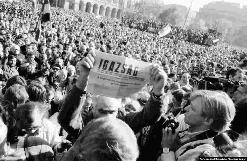 Un bărbat ține în mână un ziar ce anunță că Ungaria a devenit o republică democratică, la 23 octombrie 1989. Titlul declară acea zi drept o „victorie așteptată, dar în niciun caz întârziată”. Parlamentul Ungariei a aprobat în scurt timp modificarea constituției țării, deschizând astfel calea către alegeri libere. Președintele în exercițiu al țării, Matyas Szuros, a anunțat în fața unei mulțimi de mii de oameni, adunate la parlament: „Declar solemn că, începând de astăzi, 23 octombrie 1989, Ungaria este o republică și se numește Republica Ungară”.