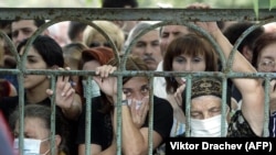 Beslan, Osetia de Nord, 2004: oamenii își caută rudele print munții de cadavre.