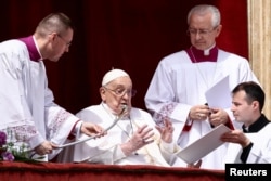 Papa Francisc este înconjurat de asistenți în balconul din Piața Sf. Petru, 20 aprilie 2025.