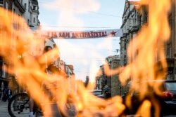 Natpis u Titovoj ulici u Sarajevu na dan mise u Katedrali, u pozadini Vječna vatra, spomenik oslobodiocima Sarajeva u Drugom svjetskom ratu