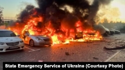 Mașini în flăcări după un atac rusesc în regiunea Kiev, pe 20 septembrie.