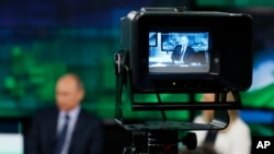 Vladimir Putin, văzut prin display-ul unei camere de luat vederi. 