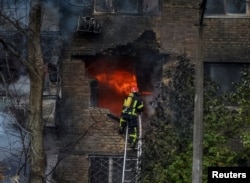 Pompierii ucraineni sting un incendiu izbucnit într-un bloc, în urma atacului cu rachete rusești, Kiev, Ucraina, 15 noiembrie 2022.