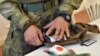 Український волонтер розглядає аптечку за стандартами НАТО