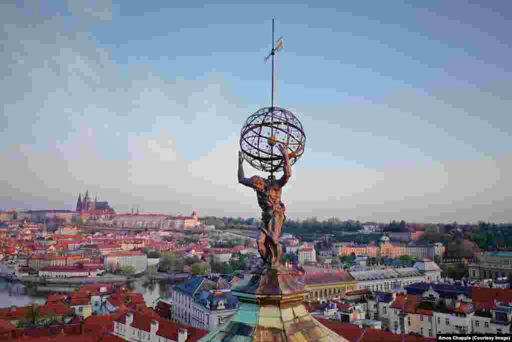 Atlasul, susținând „sfera cerească”, în vârful Clementinumului (în cehă Klementinum), un complex de clădiri istorice ce găzduiește Biblioteca Națională, precum și o stație meteorologică, datând din 1775, care este și astăzi funcțională. Statuia Atlasului a fost realizată de Matthias Bernard Braun (1684-1738), care este și autorul mai multor sculpturi de pe Podul Carol (Karlův most) din Praga.
