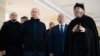 Vladimir Putin (al doilea din stânga), guvernatorul Sevastopolului, Mihail Razvojaiev (centru), și Mitropolitul Tihon (dreapta), președintele Consiliului Patriarhal pentru Cultură, vizitează un centru pentru copii din Sevastopol, Crimeea, 18 martie.