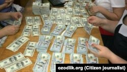 Люди считают доллары США в ходе рейда в офисе предпринимателя Ахмада Турсунбаева.
