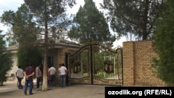 Люди стоят возле ворот офиса предпринимателя из Чиназского района Ташкентской области Ахмада Турсунбаева. 