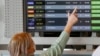 Israel - A woman checks the departures board for the flight to Kyiv before boarding at Israel's Ben Gurion airport in Lod near Tel Aviv on February 13, 2022