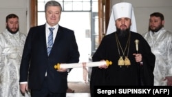 Ուկրաինայի նախագահ Պետրո Պորոշենկոն և Ուկրաինական եկեղեցու առաջնորդ Եպիֆանիոսը ձեռքերում պահել են Կոստանդնուպոլսի Տիեզերական պատրիարքի ստորագրած «տոմոսը», Կիև, 7-ը հունվարի, 2019թ․