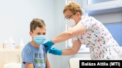 Vass Klára gyermekorvos, tüdőgyógyász főorvos beolt egy 12 éves fiút a Pfizer koronavírus elleni oltóanyagával a Jósa András Oktatókórházban kialakított oltóponton 2021. június 23-án.