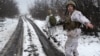 Soldații merg pe un drum înzăpezit în regiunea Luhansk din Ucraina, în decembrie 2021.