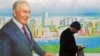 Мужчина проходит мимо баннера с портретом президента Казахстана Нурсултана Назарбаева. Алматы, 28 ноября 2012 года.