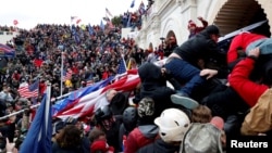 Atacul asupra Capitoliului Statelor Unite a șocat la nivel național și internațional, fiind catalogat drept un atac împotriva democrației. Îm imagine, manifestanți pro-Trump în timp ce întră în Congresul american, 6 ianuarie 2021.
