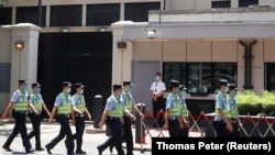 Un grup de polițiști chinezi trec pe lângă fostul sediu al Consulatului amercian din orașul chinez Chengdu, 27 iulie, 2020
