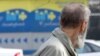 Пожилой мужчина смотрит на рекламу накопительного пенсионного фонда. Алматы, 29 марта 2012 года.